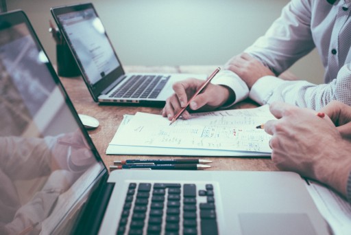 Business Ideas: person holding pencil near laptop computer