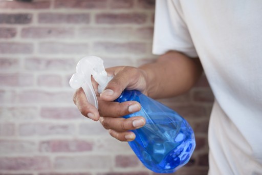 Cleaning Services: person in white shirt holding blue plastic bottle